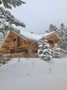 una baita di tronchi con neve sul tetto di Chalet "Le Lorgnon" a La Salle-les-Alpes