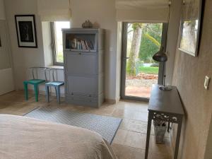 a bedroom with a dresser and a table and a window at Les Lebes - La petite maison in Sempesserre +16 photos