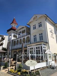 a large white building with a restaurant in front of it at Hotel Villa Waldfrieden in Ostseebad Sellin