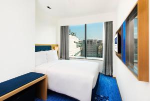 sypialnia z białym łóżkiem i dużym oknem w obiekcie Holiday Inn Express Macau City Centre, an IHG Hotel w mieście Makau