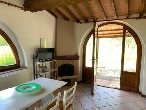 uma sala de jantar com uma mesa e uma lareira em Agriturismo L' Agresto em Casole dʼElsa