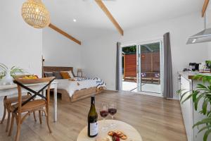 a room with a bed and a table with wine glasses at Piccolo B&B - The perfect getaway in Whitfield