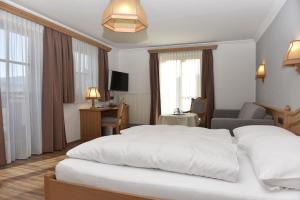 pokój hotelowy z dwoma łóżkami i krzesłem w obiekcie Gasthof Hotel Andlwirt w mieście Sankt Andrä im Lungau