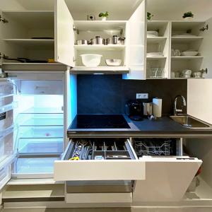 a kitchen with white cabinets and an open refrigerator at Nurban Apartments Oldtown in Nürnberg