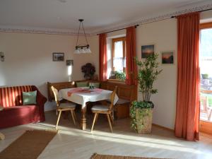 sala de estar con mesa y sofá en Haus Jung - Chiemgau Karte, en Inzell