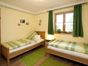two beds in a room with green curtains and a window at Haus Jung - Chiemgau Karte in Inzell