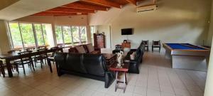 a living room with a couch and a table and chairs at Vila Rapala in Vila Praia Do Bilene