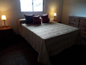 um quarto com uma cama grande e 2 candeeiros em Clima Serrano em Merlo