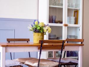 einen Esstisch mit Stühlen und Blumen darauf in der Unterkunft Apartamento Daoiz in Sevilla