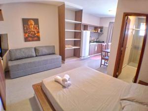 una sala de estar con una cama y un sofá en Pousada Village Ubud, en Guarda do Embaú