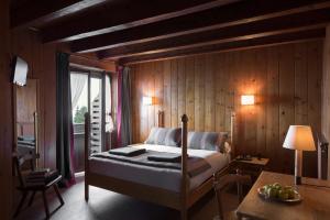 a bedroom with a bed in a wooden wall at Albergo Ristorante Bucaneve in Bielmonte