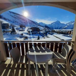 a view from a balcony with a table and chairs at Au pied des pistes avec panorama sur les montagnes in Les Deux Alpes