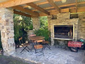 a patio with a table and a stone fireplace at Bredon Cottage in Hogsback