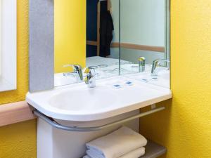 a bathroom with a sink and a mirror at ibis budget Paris Porte de Vincennes in Paris