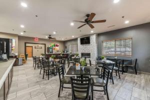 a restaurant with tables and chairs and a ceiling fan at Quality Inn & Suites Hendersonville - Flat Rock in Flat Rock