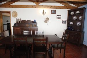 a dining room with a wooden table and chairs at Casa capelinhos in Capelo