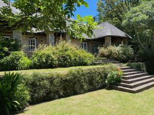 a stone house with stairs leading up to it at Bredon Cottage in Hogsback