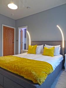 a bedroom with a large bed with yellow pillows at Sea Nest Apartment by Seaside Llandudno in Llandudno