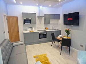 a kitchen and a living room with a couch and a table at Sea Nest Apartment by Seaside Llandudno in Llandudno
