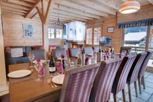 a dining room with a long table and chairs at Simply Morzine - Chalet Carving in Morzine