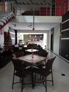 a dining room with a table and a christmas tree at Hotel ZM Premium in Cosmópolis