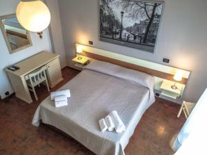 a bedroom with a bed with two towels on it at Hotel Giulia in Marina di Massa