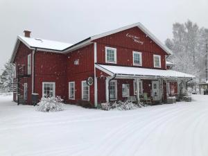 a large red barn with snow on the ground at Edsleskogs Wärdshus in Åmål