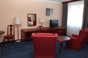 a hotel room with red chairs and a desk and a mirror at Penzion Mova in Kadaň