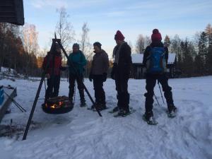 a group of people standing around a grill in the snow at Edsleskogs Wärdshus in Åmål