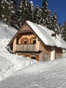 een houten hut met sneeuw erop bij Chalet Corone Monte Zoncolan in Sùtrio