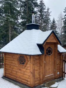domek z bali z dachem pokrytym śniegiem w obiekcie U Justina na břehu w mieście Velké Karlovice