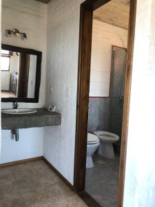 a bathroom with a toilet and a sink and a mirror at Las Pakas in La Paloma +13 photos