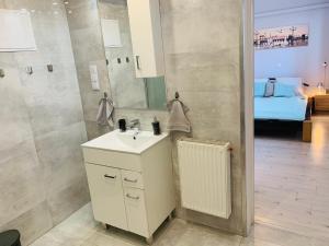 a bathroom with a sink and a mirror and a bed at Apartament Komfort Centrum Ustroń in Ustroń