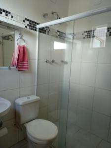 a bathroom with a toilet and a glass shower at Hotel ZM Premium in Cosmópolis