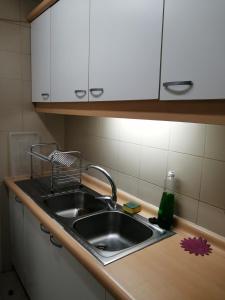 a kitchen counter with a sink and white cabinets at Temporary Rent Viña del Mar in Viña del Mar