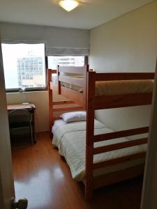 1 dormitorio con 2 literas y ventana en Temporary Rent Viña del Mar, en Viña del Mar