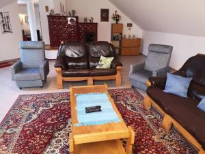 a living room with couches and chairs and a coffee table at Fortuna Apartman in Bük