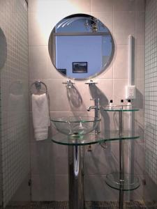 y baño con lavabo de cristal y espejo. en Quinta Alhóndiga Galindo Hotel Boutique en Cholula