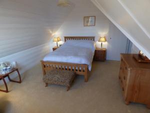 a bedroom with a bed and two tables and two lamps at Trerhose B&B in Mullion