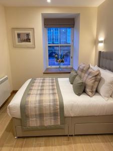 a bed with pillows on it in a room with a window at Waverley Inn Holiday Apartments in Inverness