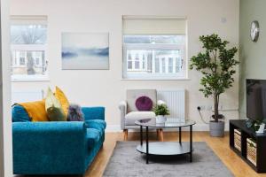 a living room with a blue couch and a table at Large Bristol Apartment-Sleeps 10 -Parking -Wifi in Bristol