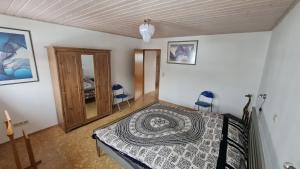 a bedroom with a bed and two blue chairs at Dörrebach bei Bingen am Rhein und Start zum Soonwald;Hunsrück in Dörrebach