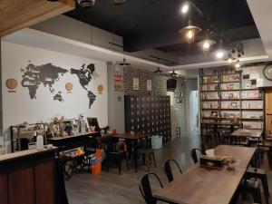 a restaurant with tables and a map of the world on the wall at 清淨背包客棧-民權館Quiet Hostel - Minquan Inn in Tainan