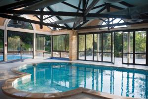a swimming pool in a house with windows at Les gites de Sarlat in Sarlat-la-Canéda
