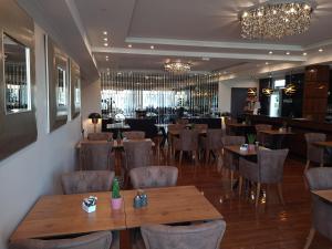 um restaurante com mesas e cadeiras de madeira e um bar em Hotel Starton am Village em Ingolstadt