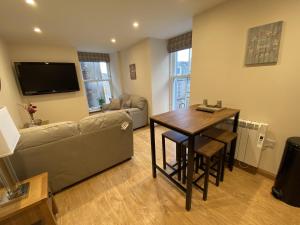 una sala de estar con un sofá y una mesa en Waverley Inn Holiday Apartments, en Inverness 158 fotos más