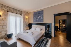 1 dormitorio con cama blanca y pared de ladrillo en Levidi Suites, en Levidhion
