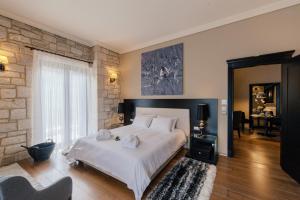 a bedroom with a white bed and a brick wall at Levidi Suites in Levidhion