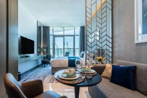 ドバイにあるThe Smart Concierge - Damac Maison Priveのキングベッド1台とリビングルームが備わる客室です。