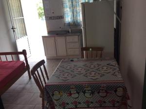 una cocina con mesa y mantel con pájaros. en Pousada do Mar, en Río Grande